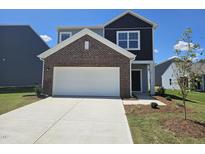 Charming two-story home with a two-car garage and brick accents under a clear blue sky at 109 Gabriel Ct, Wilson's Mills, NC 27520