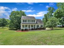 Charming two-story home with a manicured lawn and inviting front porch, surrounded by mature trees at 113 Feezor Ct, Clayton, NC 27527