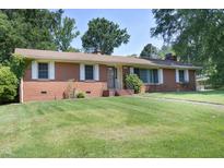 Charming single-story brick home featuring a well-maintained lawn and mature trees at 1209 Landon St, Durham, NC 27703