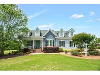 Charming home showcasing landscaped yard, dormer windows, and a welcoming front porch at 14393 Nc Hwy 96 N, Zebulon, NC 27597