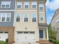 Charming multi-story townhouse with a one-car garage and a beautifully designed facade with varying materials and textures at 1466 Salem Creek Dr, Apex, NC 27502