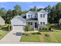 Stunning two-story home boasts a manicured lawn, stone accents, and an attached two-car garage at 1612 Commons Ford Pl, Apex, NC 27539