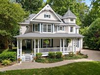 Charming two-story home with a large, inviting front porch and beautifully landscaped yard at 1702 Mcrae Pl, Hillsborough, NC 27278