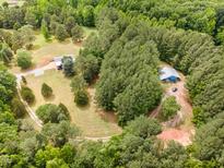 Expansive aerial view of wooded property with home and outbuilding at 197 Country Routt Brown Rd, Pittsboro, NC 27312