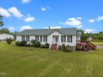Charming single-story home featuring green shutters, mature landscaping, and a welcoming front lawn at 1993 Lucy Garrett Rd, Roxboro, NC 27574