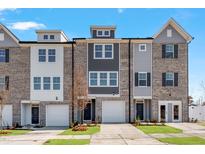 Modern townhome exterior with brick facade, attached garages, and well-maintained landscaping at 2034 Fishamble St # 30, Fuquay Varina, NC 27526