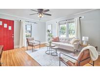 Inviting living room featuring a stylish sofa, chairs, ceiling fan, and plenty of natural light at 2616 Kirk Rd, Durham, NC 27705