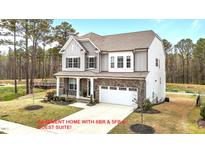 Charming two-story home featuring stone accents, gray siding, a two-car garage, and a well-manicured lawn at 3020 Mavisbank Cir, Apex, NC 27502