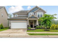 Charming two-story home featuring a two-car garage and a well-manicured lawn at 304 Avery Glenn Way, Fuquay Varina, NC 27526