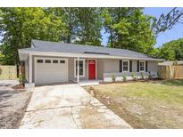 Charming single-story home features a vibrant red door and a well-manicured front yard at 3204 Winfield Ct, Raleigh, NC 27610