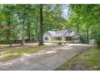 Charming, traditional home with a covered porch, well-manicured landscaping, and a long driveway leading to the residence at 352 Riverstone Dr, Clayton, NC 27527
