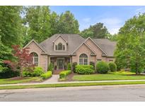 Charming brick home with manicured lawn, mature trees, and arched windows creates inviting curb appeal at 3994 Limerick Dr, Burlington, NC 27215