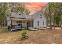 Charming exterior view of a two-story home with manicured landscaping and inviting front porch at 5163 S River Rd, Lillington, NC 27546