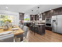 Stylish kitchen features an island, stainless steel appliances, wood floors and a dining area at 531 N Person St # 205, Raleigh, NC 27604