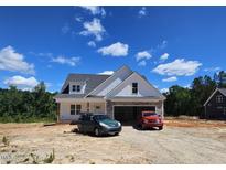 Charming new construction home with stone accents, white siding, and a two-car garage at 55 Stream View Way, Spring Hope, NC 27882