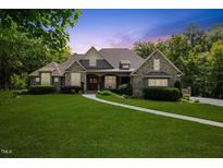 Charming two-story home with stone accents, lush lawn, and professionally landscaped yard at 6500 Bass Mountain Rd, Snow Camp, NC 27349