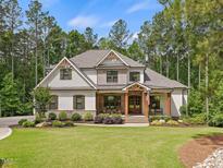 Charming two-story home featuring manicured landscaping and a welcoming front porch with rustic wood columns at 67 Spring Hollow Ct, Pittsboro, NC 27312