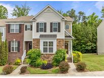 Charming townhouse featuring a mix of brick and siding, complemented by lush landscaping and beautiful shrubbery at 100 Stratford Lakes Dr # 270, Durham, NC 27713