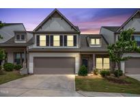 Two-story townhouse showcasing a manicured lawn, two car garage and exterior brick accent at 107 Explorer Dr, Morrisville, NC 27560
