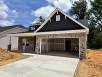 Charming new construction home with a two-car garage and brick accents under a bright sky at 1087 Fairhaven Dr # 48, Mebane, NC 27302