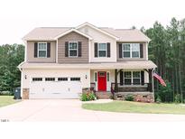 Charming two-story home with a bright red front door and well-manicured landscaping at 123 Scheer Ave, Durham, NC 27703