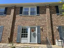 Charming brick townhome with blue shutters and a welcoming front entrance at 129 Friar Ln, Carrboro, NC 27510