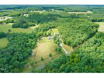 Sprawling estate showcasing a meticulously maintained home, surrounded by lush greenery and fenced pasture at 1717 Ormond Rd, Hurdle Mills, NC 27541