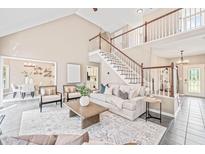 Bright living room with high ceilings, a staircase, and an open floor plan with a neutral color palette at 1717 Ormond Rd, Hurdle Mills, NC 27541