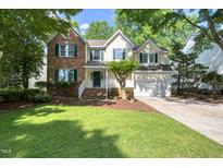 Charming two-story home with a combination of brick and siding, lush lawn, and mature trees at 203 Halls Mill Dr, Cary, NC 27519