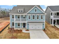Charming two-story home with blue siding, white trim, a second-story balcony, and a two-car garage at 219 Berry Mill Ln # 179, Raleigh, NC 27603