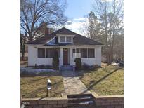 Charming single-story home featuring a brick pathway and a well-maintained front yard and mature trees at 2309 Chautauqua Ave, Durham, NC 27707