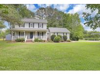 Charming two-story home with a welcoming front porch and lush green lawn at 2312 Brasswynd Ct, Fuquay Varina, NC 27526