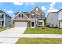 Charming two-story home featuring a stone facade, two-car garage, and a well-manicured lawn at 33 Black Walnut Dr # 185, Garner, NC 27529