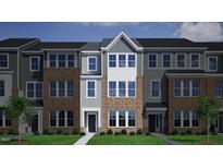 Beautiful new townhome exterior featuring brick and gray siding, complemented by professionally landscaped front yard at 367 Chesapeake Cmns St # 115, Garner, NC 27529