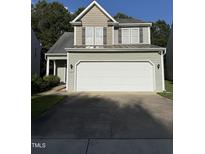 Home featuring a two-car garage, gray siding, and complementary brown accents at 4009 Patriot Ridge Ct, Raleigh, NC 27610
