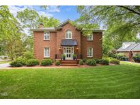 Charming brick two-story home featuring a well-manicured lawn and a welcoming front entrance with a black awning at 441 Fieldstone Dr, Burlington, NC 27215