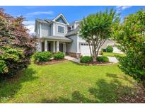 Charming two-story home with manicured lawn, flowering trees, and a welcoming front porch at 4502 Joe Cotton Dr, Knightdale, NC 27545