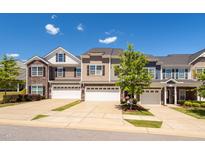 Charming townhomes featuring varied siding, stone accents and attached two-car garages at 512 Barneswyck Dr, Fuquay Varina, NC 27526