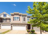 Inviting townhome with a well-manicured front lawn and a convenient two-car garage on a bright day at 512 Barneswyck Dr, Fuquay Varina, NC 27526