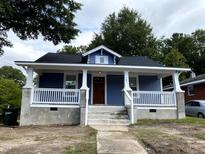 Charming blue home featuring a cozy front porch with white columns and railings at 701 Linwood Ave Ave, Durham, NC 27701