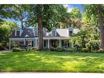 Charming single-Gathering home boasts a lush green lawn and mature trees, complete with a covered porch and traditional dormers at 924 Pebblebrook Dr, Raleigh, NC 27609