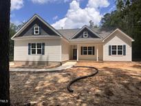 Charming single-story home with navy blue shutters and gables, complemented by a landscaped yard at 987 Lewis Rd, Zebulon, NC 27597