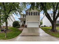 Two-story home featuring a white garage door and black shutters against light siding under a blue sky at 109 Troyer Pl, Apex, NC 27502