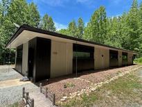 Modern house exterior with sleek lines, contrasting trim, and natural landscaping offering a tranquil setting at 1115 Sepelo Way, Efland, NC 27243