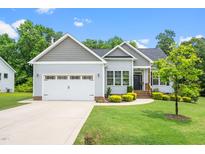 Charming single-Gathering home featuring manicured lawn, attached garage, and welcoming front porch at 115 Jensen Dr, Wendell, NC 27591