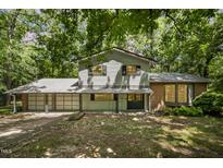 Two-story home with attached garage, and a yard surrounded by mature trees at 134 Chateau Rd, Durham, NC 27704