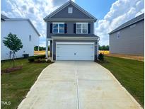 Charming two-story home with a two-car garage and a well-manicured lawn at 136 Bruce Dr Dr, Dunn, NC 28334