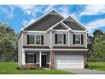 Charming two-story home featuring gray siding, stone accents, and a well-manicured lawn at 16 Freedom Heights Ln, Smithfield, NC 27577