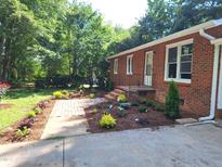 Charming brick home featuring a beautifully landscaped yard and inviting entryway at 2085 Enon Rd, Oxford, NC 27565