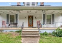 Inviting front porch with classic railings, seating, and a charming entryway leading to the home's entrance at 219 W Parker St, Graham, NC 27253